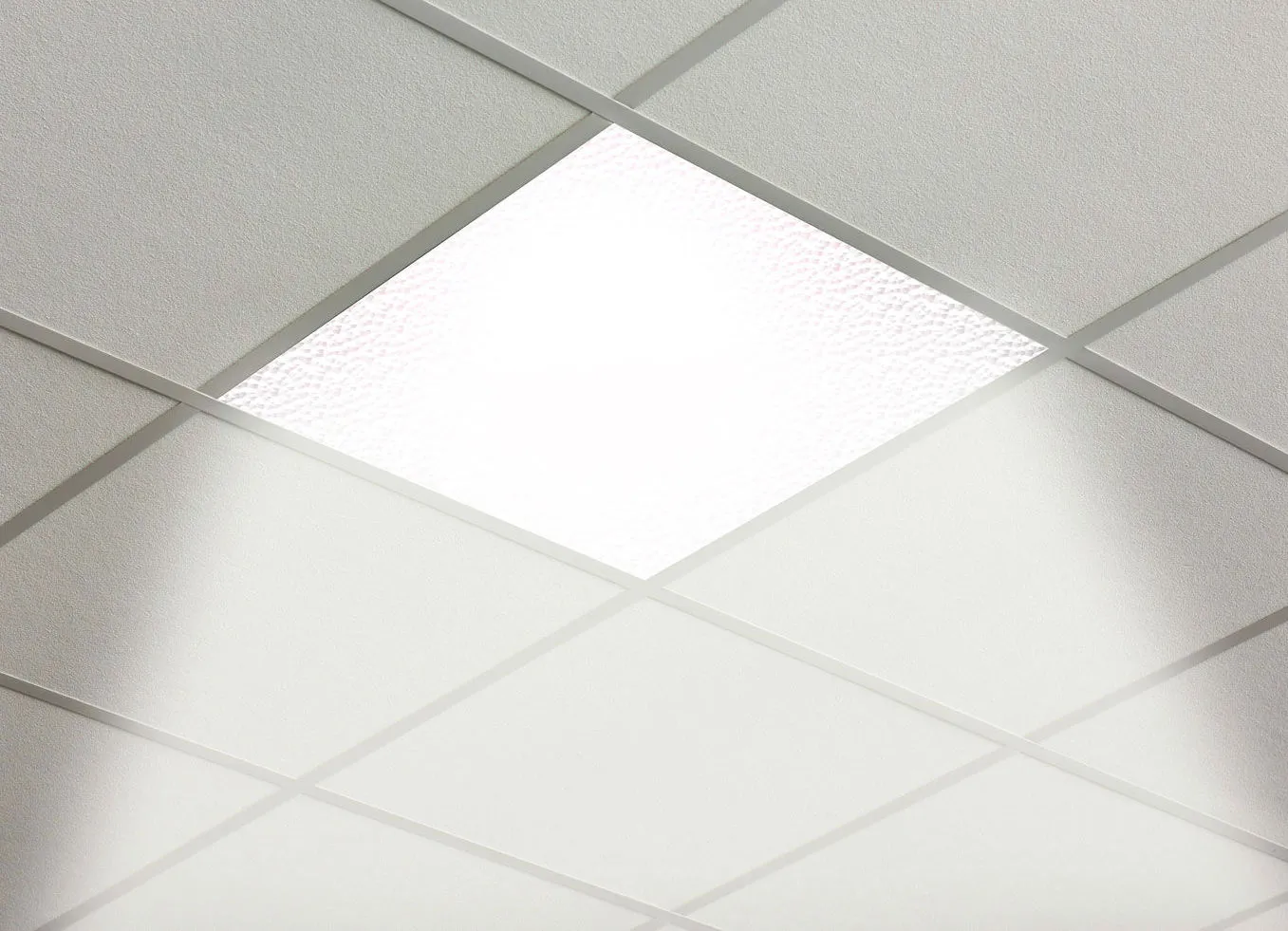 Edge-lit LED panel glowing in a suspended ceiling grid