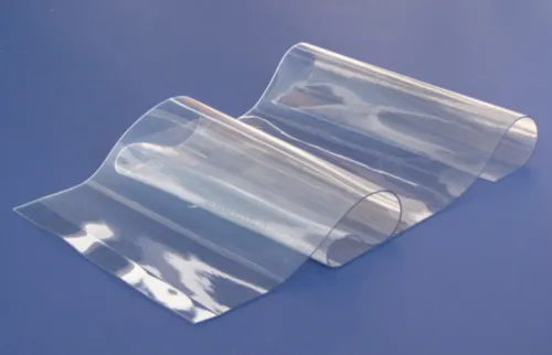 Sheet of clear, flexible Daylighting Fabric® film curved into waves on a blue background