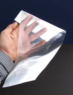 Hand holding a thin, flexible sheet of Daylighting Fabric®