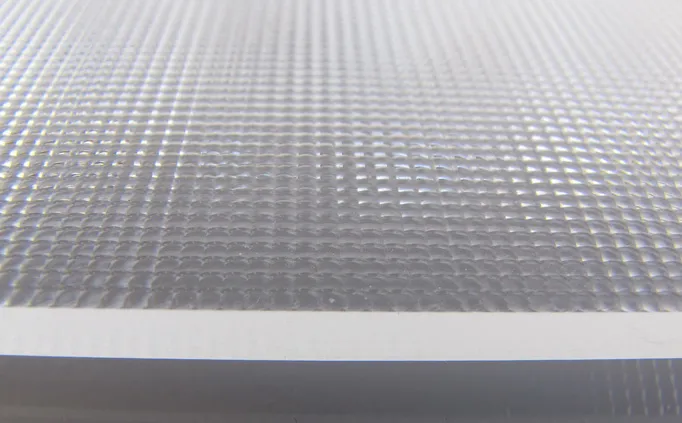 Close-up of a clear light guide plate with a two-dimensional lens array texture on its surface