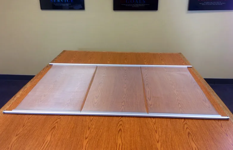 Window shade made of three translucent Luminyl™ panels between aluminum rails, lying on a conference table