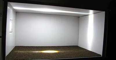 The same scaled room model with Daylighting Film: sunlight is redirected to the ceiling and walls, lighting the whole room