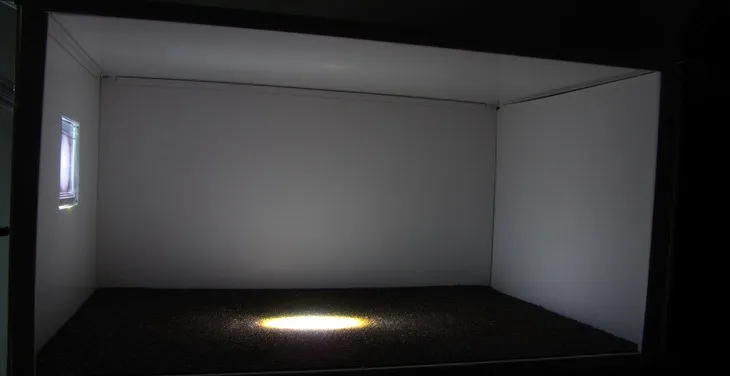 Scaled room model with plain glazing: a dim interior with a bright hot spot of sunlight on the carpeted floor