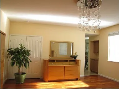 The same living room after the film is installed: sunlight is redirected to the ceiling and the room is evenly brighter