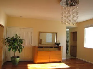 Living room before film installation: direct sunlight makes a bright patch on the floor while the rest of the room stays dim