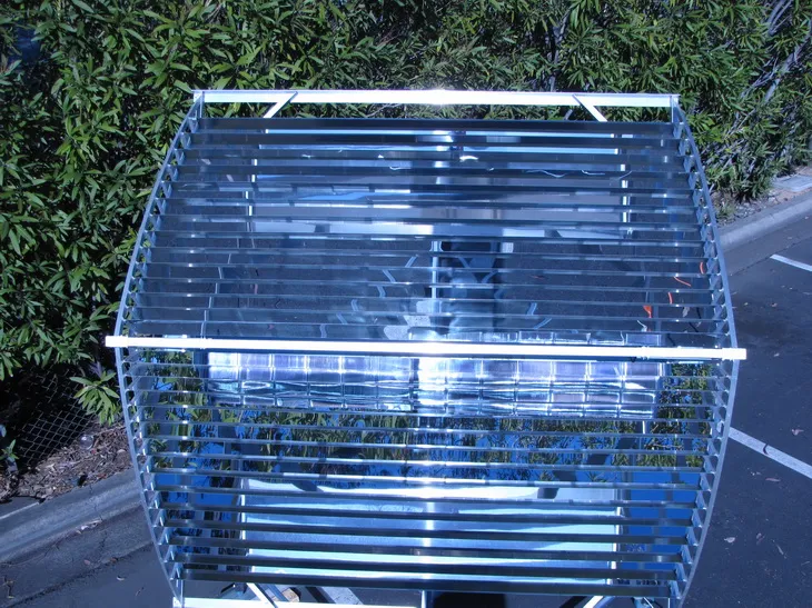 Outdoor CPV system: a barrel-shaped metal frame filled with horizontal reflective slats